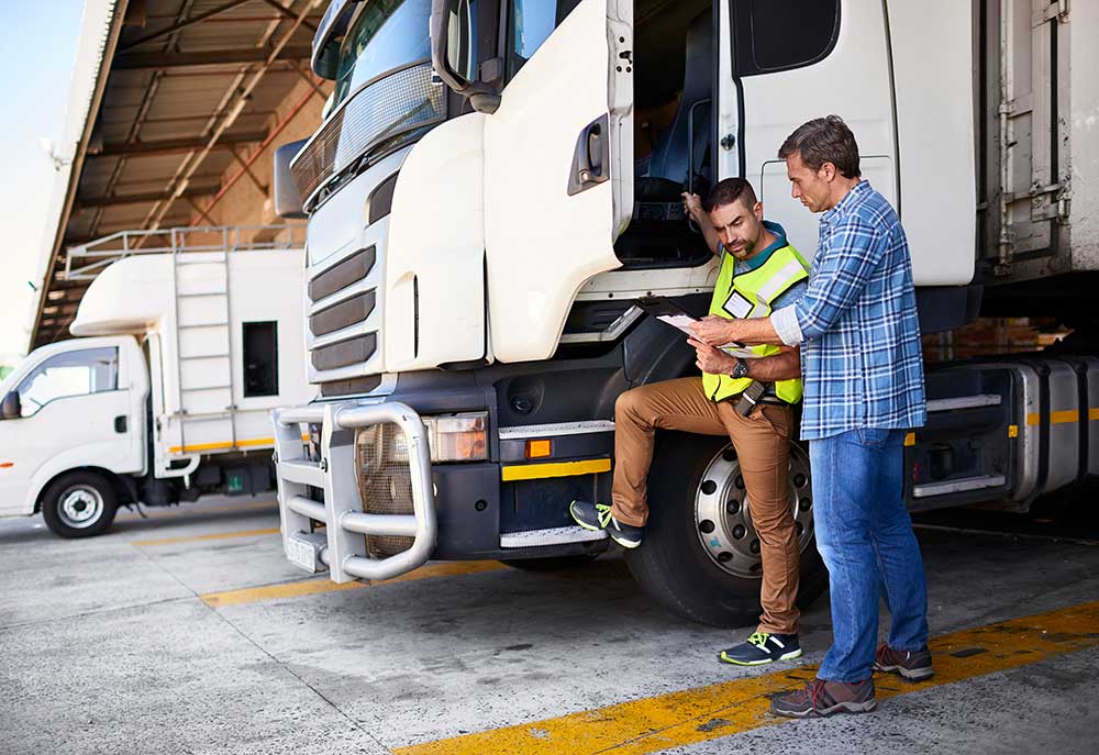 men with a tablet next to a truck