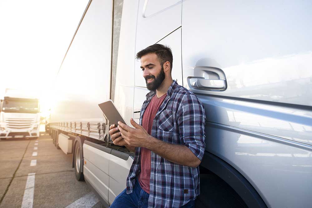 man with a tablet next to a trailer